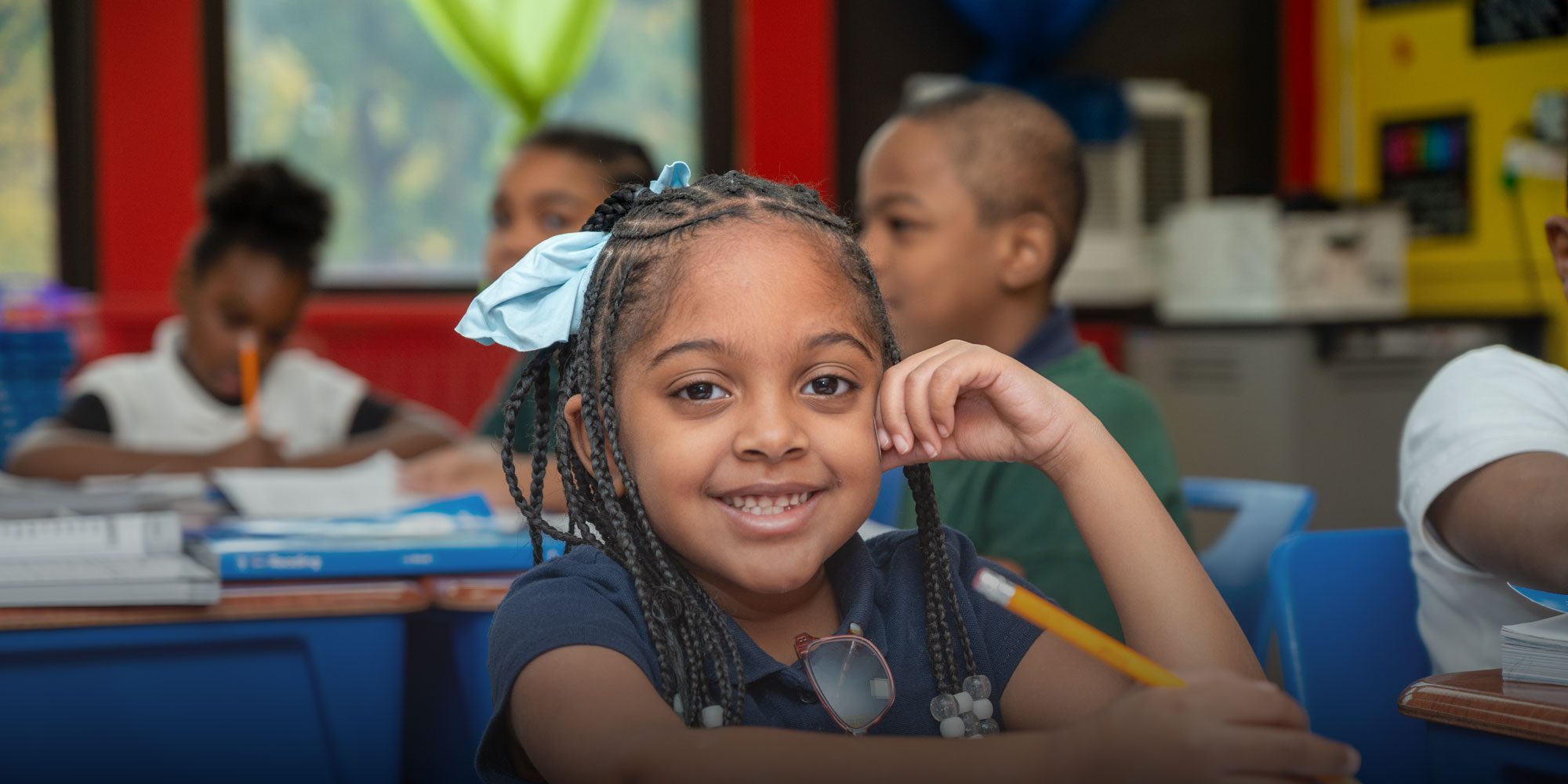 Elementary student smiling and working at desk