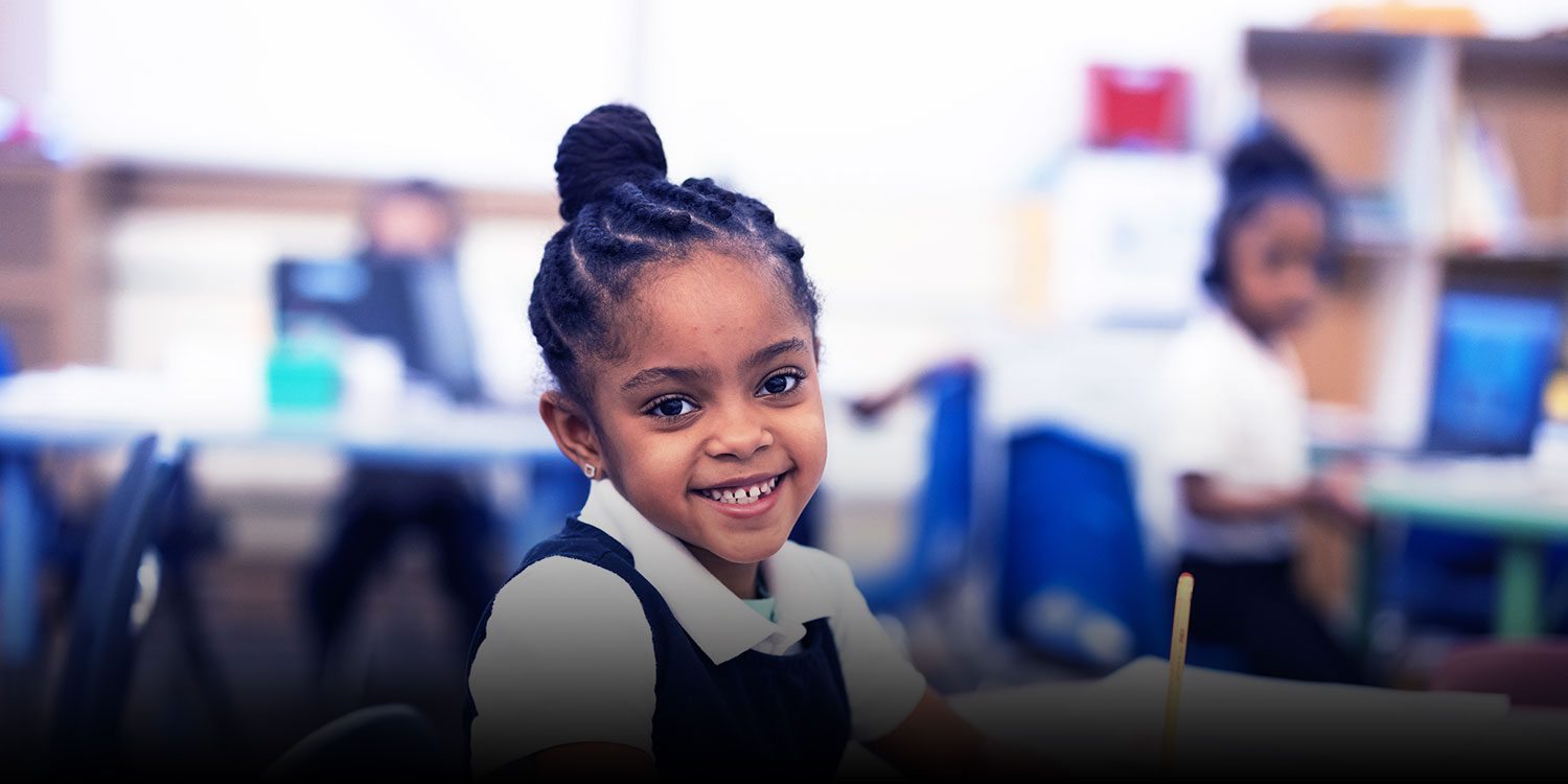 Smiling student in a classroom.